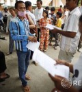 People read statements distributed by the opposition party in Phnom Penh