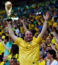 A fan of Brazil holding a mock World Cup trophy cheers during their Confederations Cup final soccer match against Spain at the Estadio Maracana in Rio de Janeiro