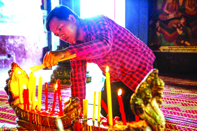 Man lighting encences in Wat Phrom during New Year in Phnom Penh