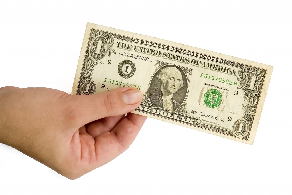 Female hand with one dollar on a white background.