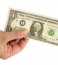 Female hand with one dollar on a white background.
