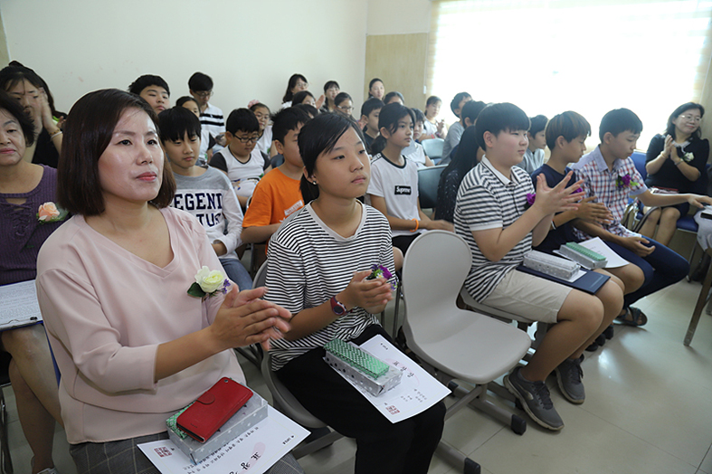 송사와 답사 시간이 끝나고 재학생과 교사 학부모 일동이 박수를 치고 있다