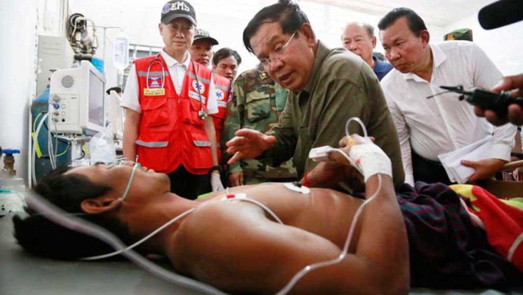 Prime Minister Hun Sen visits a victim retrieved from the debris of a six-storey building collapse in Kep province.