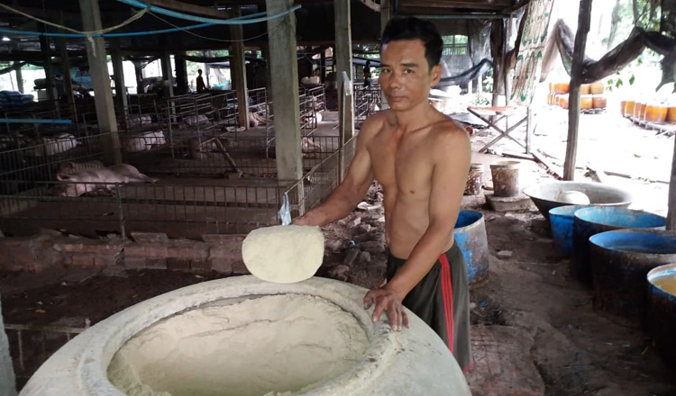 돼지 먹이로 쓰는 쌀가루를 보여주는 양돈업자 겸 주조업자