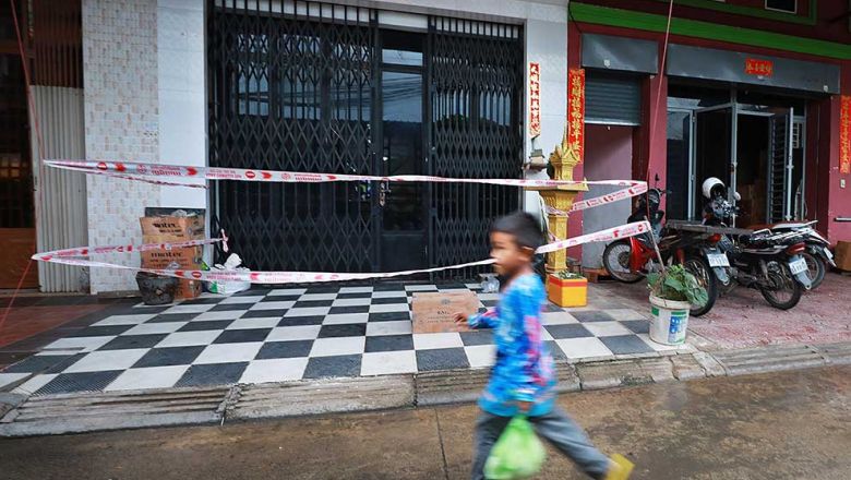 a_boy_walks_in_front_of_a_house_where_a_family_member_tested_positive_for_covid-19_in_stung_meanchey_commune_of_the_capitals_meanchey_district_last_june._hong_menea