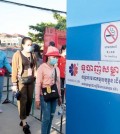 a_factory_security_guard_takes_the_temperature_of_workers_before_they_enter_a_factory_in_phnom_penhs_por_sen_chey_district_last_july._heng_chivoan