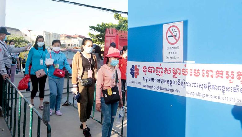 a_factory_security_guard_takes_the_temperature_of_workers_before_they_enter_a_factory_in_phnom_penhs_por_sen_chey_district_last_july._heng_chivoan