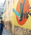 poy_chhunly_guides_tourists_to_see_graffiti_and_street_art_murals_in_battambang_town._supplied