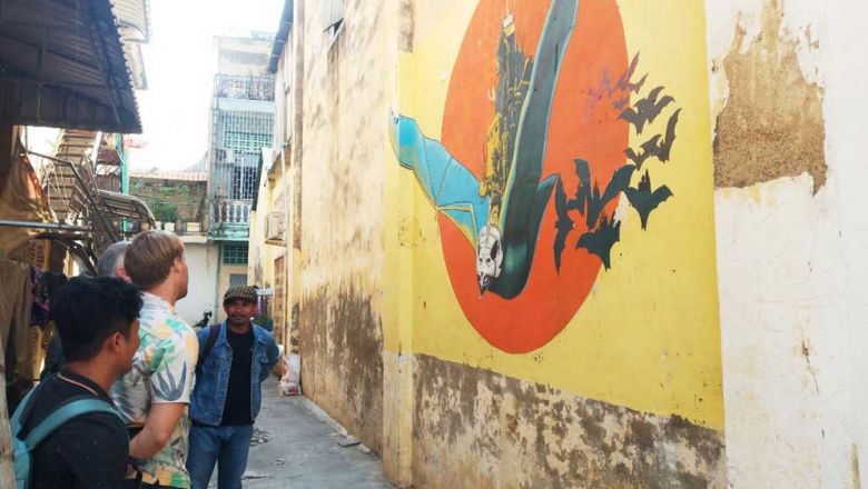 poy_chhunly_guides_tourists_to_see_graffiti_and_street_art_murals_in_battambang_town._supplied