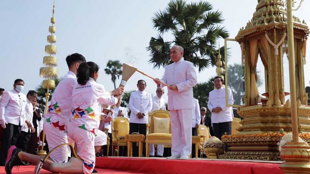 king_norodom_sihamoni_lights_the_sea_games_torch_held_by_two_athletes_at_angkor_wat_temple_on_the_morning_of_march_21_as_prime_minister_hun_sen_right_and_interior_minister_sar_kheng_centre_look_on._spm