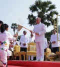 king_norodom_sihamoni_lights_the_sea_games_torch_held_by_two_athletes_at_angkor_wat_temple_on_the_morning_of_march_21_as_prime_minister_hun_sen_right_and_interior_minister_sar_kheng_centre_look_on._spm