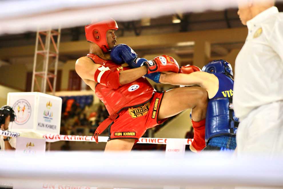 28_3_2024_kun_khmer_boxer_lao_chetra_in_red_launches_a_knee_strike_at_his_vietnamese_opponent_during_the_32nd_sea_games_in_cambodia_in_may_2023_hong_menea
